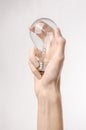 Energy consumption and energy saving topic: human hand holding a light bulb on a white background in studio