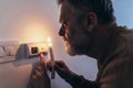 Man in complete darkness holding a candle to investigate thermostat during a power outage. Blackout concept Royalty Free Stock Photo