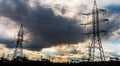 Energy Distribution Network - Electricity Pylons against Orange and Yellow Sunset. Royalty Free Stock Photo