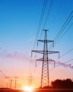 Energy Distribution Network - Electricity Pylons against Orange and Yellow Sunset. Royalty Free Stock Photo