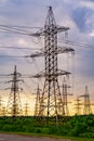 Energy distribution network. Electricity pylons against orange and yellow sunset. Selective focus. Royalty Free Stock Photo