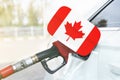 Flag of Canada on the car`s fuel filler flap with gas pump nozzle in the tank Royalty Free Stock Photo