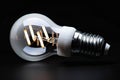 Energy efficient white bulb glows on dark black backdrop impressively Royalty Free Stock Photo