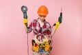 Energy fun handyman woman in gloves, protective orange helmet, kit tools belt full of instruments holding power saw Royalty Free Stock Photo