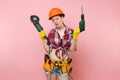 Energy fun handyman woman in gloves, protective orange helmet, kit tools belt full of instruments holding power saw Royalty Free Stock Photo