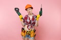 Energy fun handyman woman in gloves, protective orange helmet, kit tools belt full of instruments holding power saw Royalty Free Stock Photo