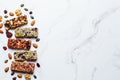 Energy granola bars with different seeds, nuts and dried fruits and berries on white marble background. Healthy snack concept Royalty Free Stock Photo