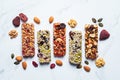 Energy granola bars with different seeds, nuts and dried fruits and berries on white marble background. Healthy snack concept Royalty Free Stock Photo