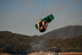 energy guy makes dangerous stunts jumping and flips on wakeboard over splashing wave Royalty Free Stock Photo