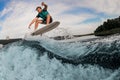 energy male wakeboarder performs tricks and jump over splashing river wave Royalty Free Stock Photo