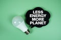 Less Energy, More Planet with light bulb on green background Royalty Free Stock Photo