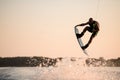 energy muscular man making trick in jump time with wakeboard against the backdrop of the sky Royalty Free Stock Photo