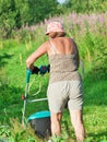 Energy old lady trimmering grass in kaleyard