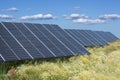 Solar panels in green meadow on blue sky Royalty Free Stock Photo