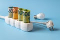 Energy price spike. Rising of electricity bill payment. Euro banknotes plugged into electrical outlet, light bulb and white power Royalty Free Stock Photo