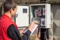 An energy sales worker takes readings of electricity meters