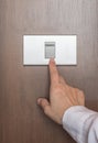 Energy saving concept with business woman`s hand turn off switch light button on wood panel Royalty Free Stock Photo