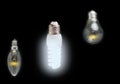 Energy-saving concept of innovation of bright fluorescent lamps, green technology and old dim incandescent bulbs. Royalty Free Stock Photo