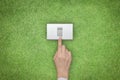 Energy saving and ecological friendly concept with hand turning off switch on green grass lawn Royalty Free Stock Photo