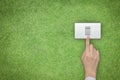 Energy saving and ecological friendly concept with hand turning off switch on green grass lawn Royalty Free Stock Photo