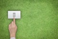 Energy saving and ecological friendly concept with hand turning off switch on green grass lawn Royalty Free Stock Photo