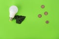 energy-saving lamp, green leaf and euro coins on a green background. top view. Energy savings concept. Place for text Royalty Free Stock Photo