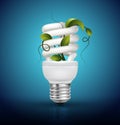 Energy saving lamp with lightbulb and green leaves Royalty Free Stock Photo