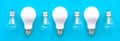 Energy-saving lamps with incandescent lamps in a row on a blue background. The concept of saving energy Royalty Free Stock Photo