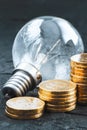 Energy saving.Old lamp. Money coins on a dark background. Energy saving. Stack of coins Royalty Free Stock Photo