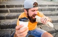 Energy from street food daily traditional snack. Man bearded shows paper cup drink stairs background. Take coffee with