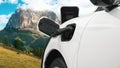 Progressive travel concept by EV car in remote mountain with charging station.