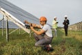 Indian technician examining solar panels with multimeter Royalty Free Stock Photo