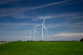 Three wind turbines on green fields against a blue sky Royalty Free Stock Photo