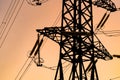 Energy transmission towers or electricity pylons with golden sky and clouds. Selective focus. Cropped photo from below. Royalty Free Stock Photo