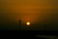 Energy wind turbine rotating fields at sunset