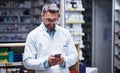 We engage with customers via text for added convenience. a mature pharmacist using a cellphone in a pharmacy. Royalty Free Stock Photo