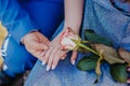 Engagement day. Just engaged young couple holding hands with rose Royalty Free Stock Photo