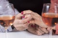 Engagement. Man puts a diamond ring on a woman`s finger. Wine glasses are standing next to Royalty Free Stock Photo