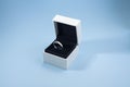 An engagement ring in a box on a blue background. Wedding ring in a box Royalty Free Stock Photo