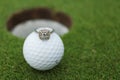 Engagement/Wedding ring alongside a golf ball