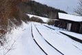 Engeln, Germany - 01 26 2021: snow coverd railroad tracks at the station with wind pwer in background