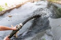 Engeneer hold pipe of power pump machine pouring mud sludge waste water with sand silt on ground. Sand-wash and coast-depeening.