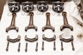 Engine connecting rods and pistons used and removed from a four-cylinder engine on a white soft cloth in a vehicle repair workshop Royalty Free Stock Photo