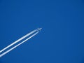 4 engine jet with contrails in blue winter sky