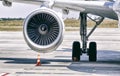 Engine of modern passenger jet airplane. Rotating fan and turbine blades. Traffic cone near it. Landing gear. Close-up front view. Royalty Free Stock Photo
