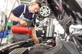 engine oil change from the car by a mechanic in the car workshop Royalty Free Stock Photo