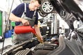 Engine oil change from the car by a mechanic in the car workshop Royalty Free Stock Photo