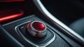 Engine start stop button on modern car dashboard with metallic red finish and chrome edges against sleek black leather Royalty Free Stock Photo