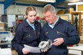 Engineer With Apprentice Looking At Component In Factory Royalty Free Stock Photo