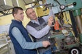 Engineer and apprentice using automated milling machine Royalty Free Stock Photo